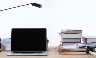 Desk with laptop, lamp and books